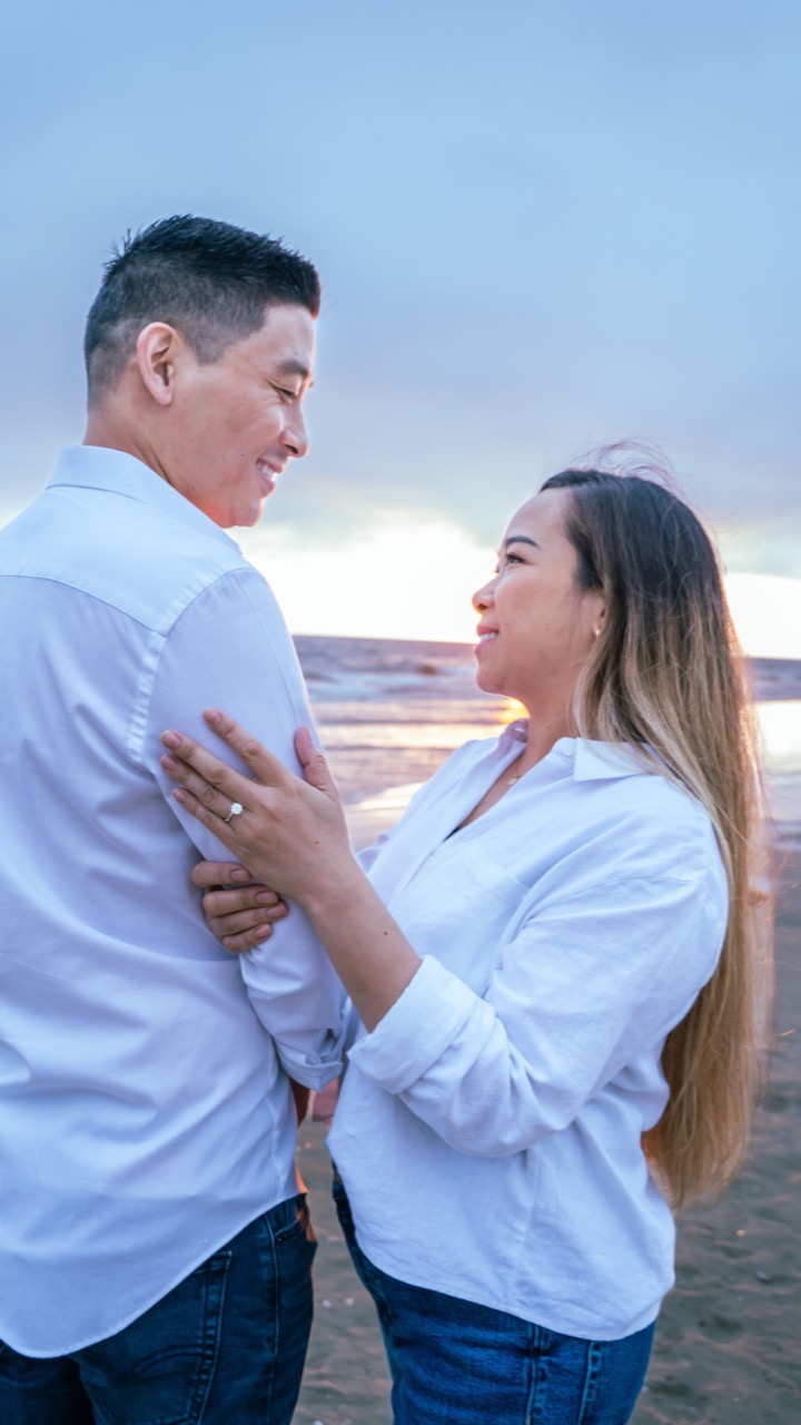 Rhona and Francis looking at each other on the shore at sunset
